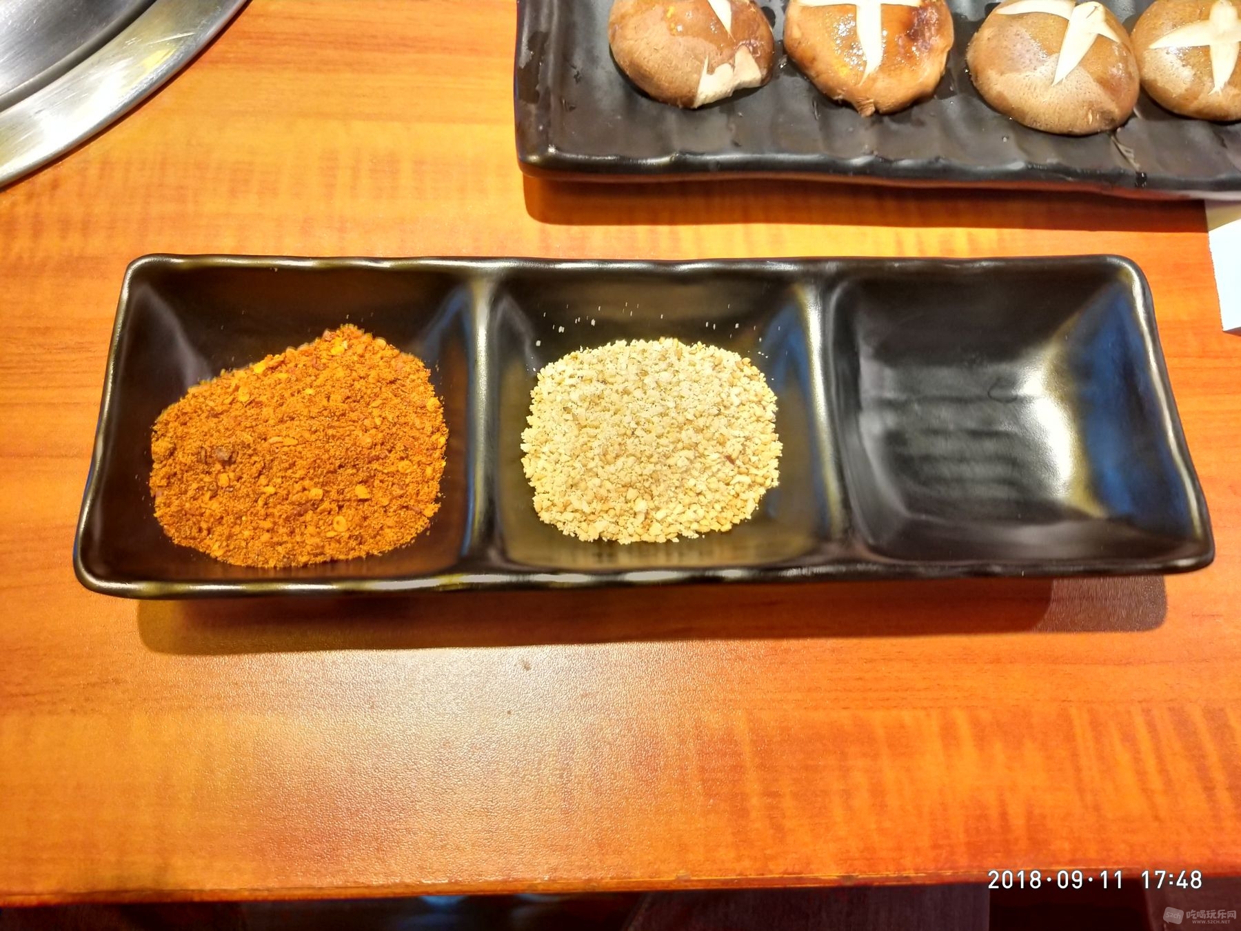 料碟，左边是辣椒和盐，中间花生碎，右边空的，可以根据自己口味放店里的秘制烤肉酱料或者酱油芥末